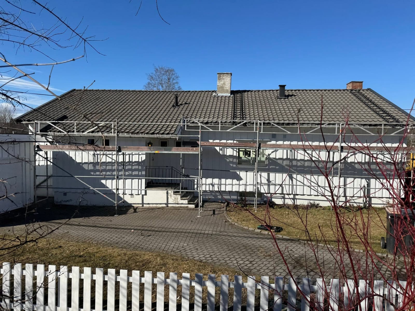 Huset på Bekkestua før omleggingen, med det gamle betongtaket og stillas langs veggen.